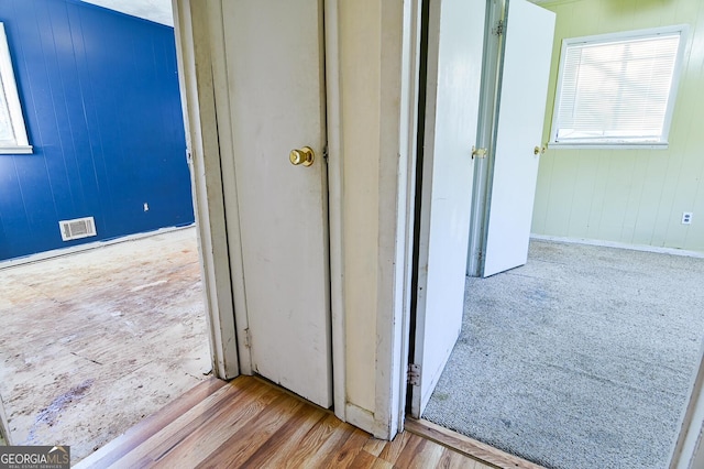 hallway with visible vents and wood finished floors