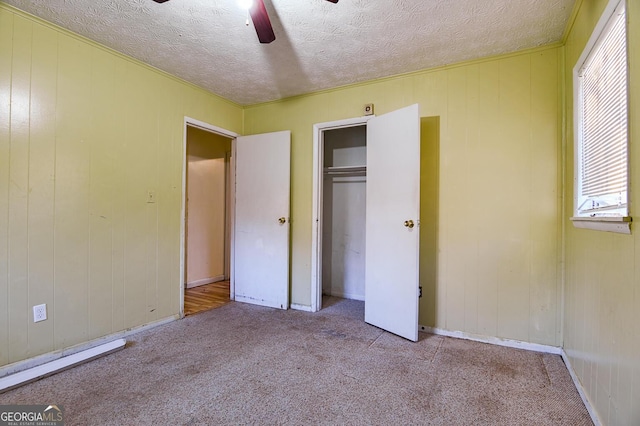 unfurnished bedroom featuring a closet, carpet flooring, a textured ceiling, and a ceiling fan