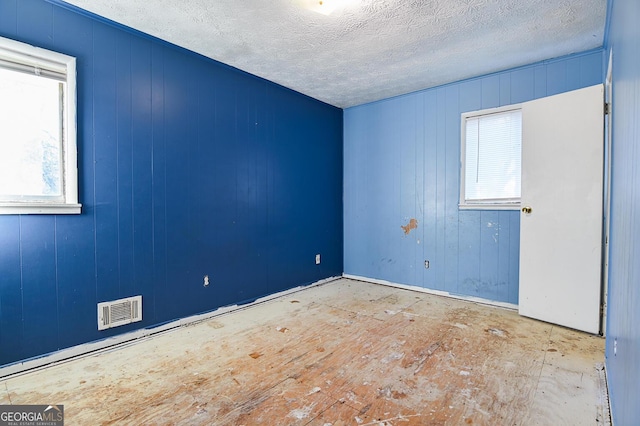 unfurnished room with visible vents and a textured ceiling