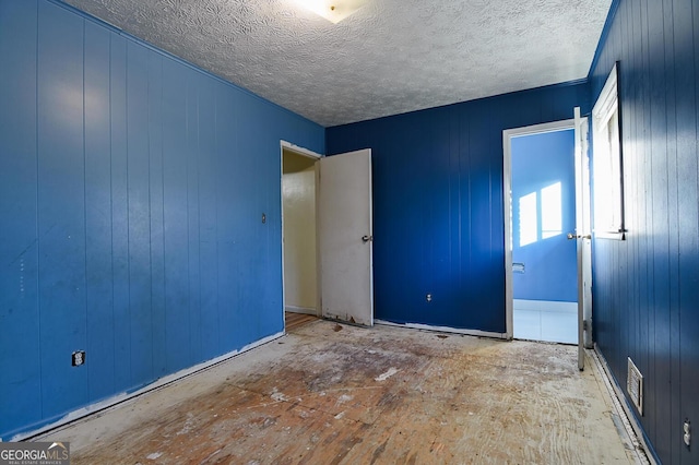 unfurnished bedroom featuring visible vents and a textured ceiling