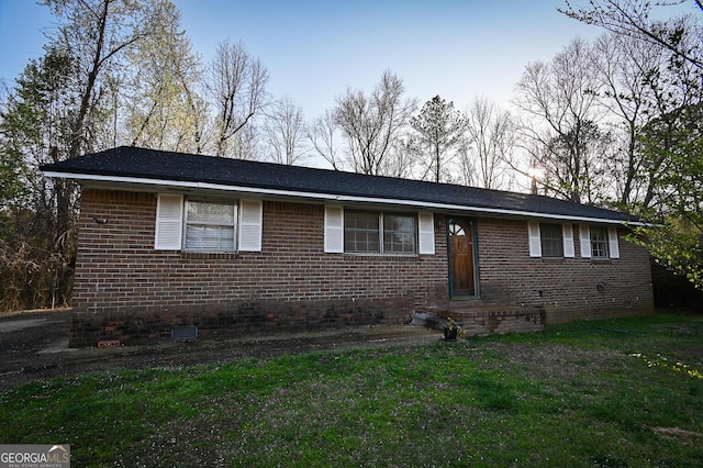 ranch-style house featuring crawl space, brick siding, and a front lawn