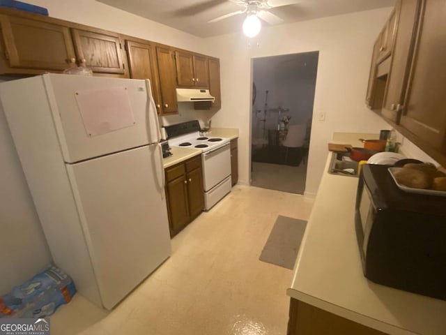 kitchen with under cabinet range hood, white appliances, ceiling fan, and light countertops