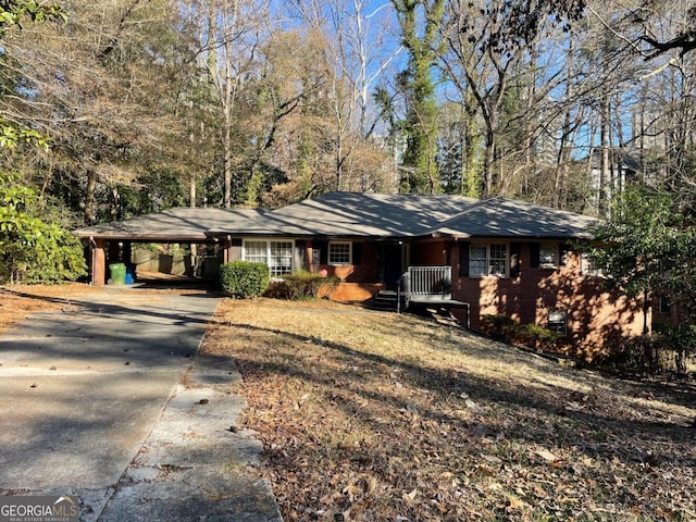 single story home featuring a carport, a porch, and driveway