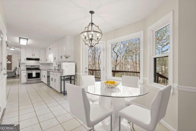 dining room featuring light tile patterned flooring, baseboards, and an inviting chandelier