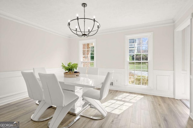 dining room featuring a notable chandelier, light wood-style flooring, and ornamental molding