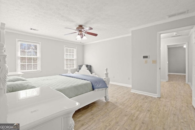 bedroom with light wood-style floors, visible vents, and ornamental molding