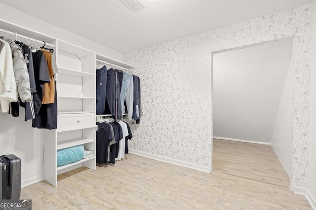 walk in closet with visible vents and wood finished floors