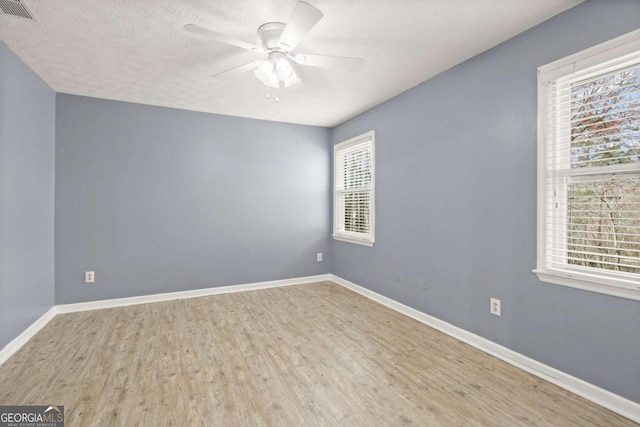 spare room with a wealth of natural light, visible vents, and baseboards