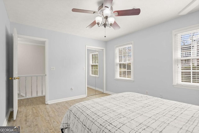 bedroom featuring light wood-style flooring, a ceiling fan, and baseboards