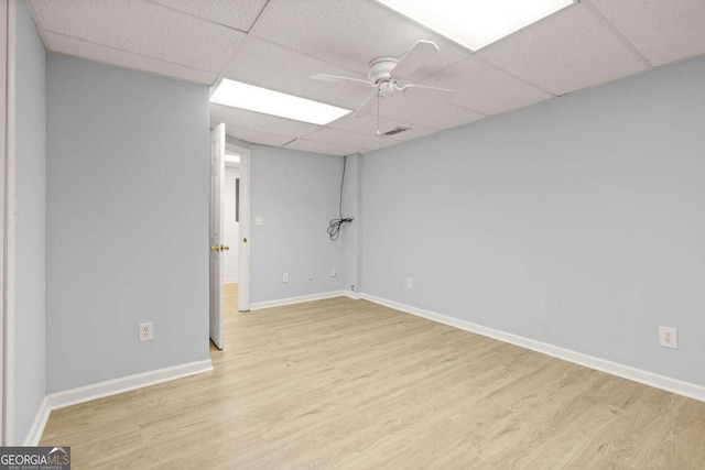 spare room with visible vents, ceiling fan, baseboards, wood finished floors, and a paneled ceiling