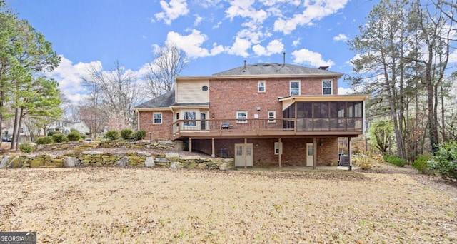 back of house with brick siding, central AC, and a sunroom