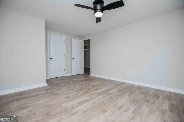 unfurnished bedroom with baseboards, a textured ceiling, wood finished floors, and a ceiling fan