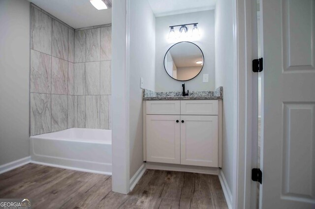 bathroom featuring vanity, wood finished floors, and baseboards