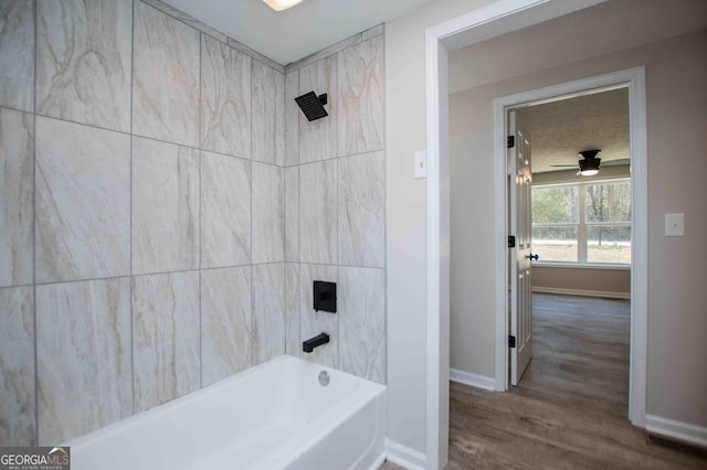 bathroom featuring tub / shower combination, baseboards, a textured ceiling, and a ceiling fan