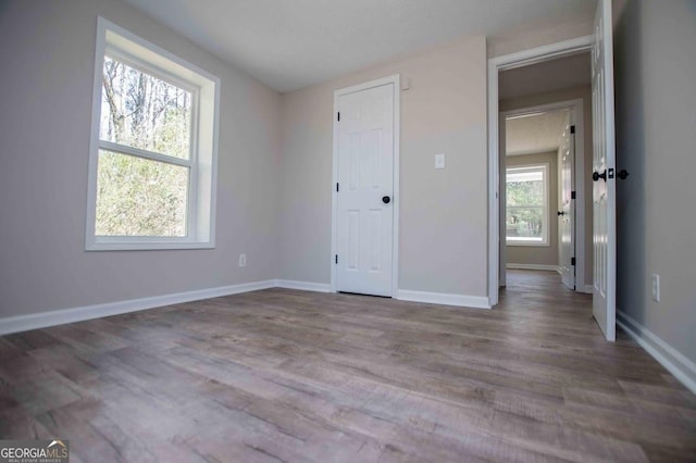 unfurnished bedroom featuring wood finished floors and baseboards