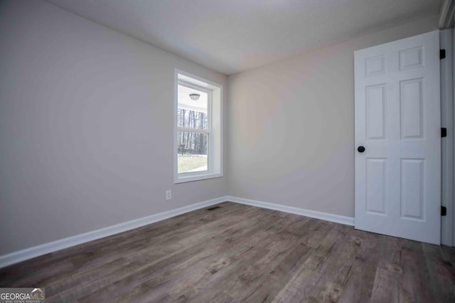 empty room featuring baseboards and wood finished floors