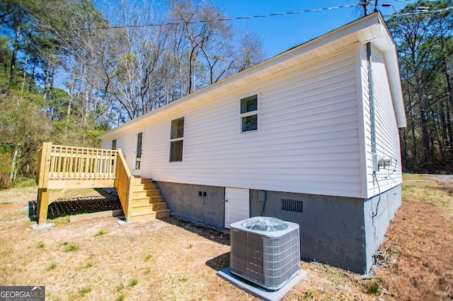 view of side of property with crawl space, a deck, stairway, and central AC