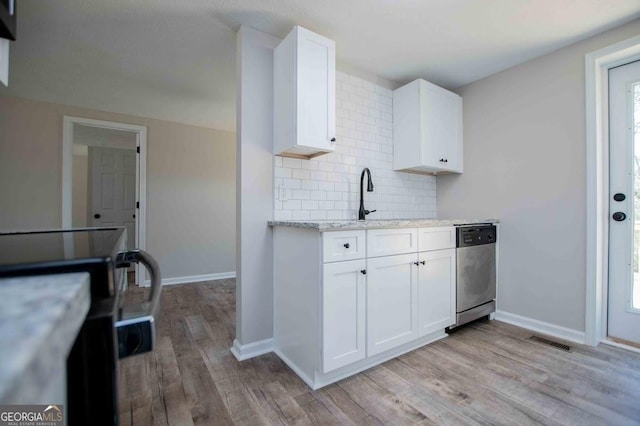 kitchen with visible vents, backsplash, dishwasher, and light wood-type flooring