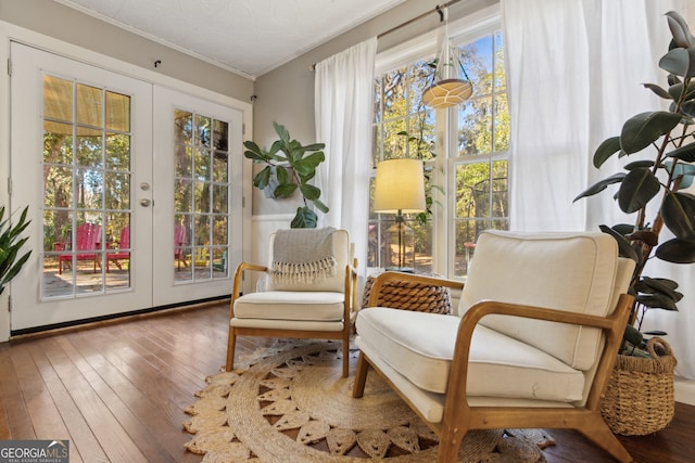 sitting room with hardwood / wood-style floors, french doors, and a healthy amount of sunlight