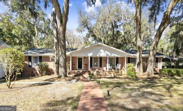 ranch-style home with a porch and brick siding