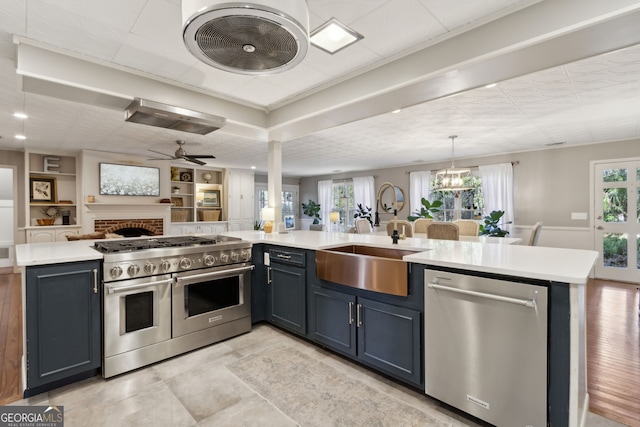 kitchen with a sink, appliances with stainless steel finishes, open floor plan, and light countertops