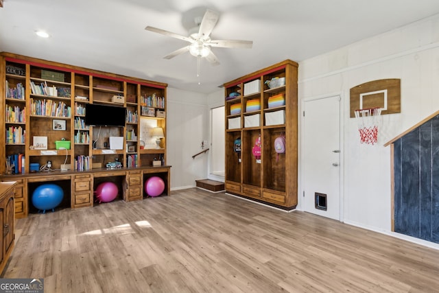 exercise area featuring a ceiling fan and wood finished floors