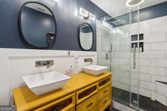 bathroom with a sink, visible vents, double vanity, and a shower stall