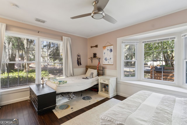 bedroom featuring a ceiling fan, baseboards, visible vents, dark wood finished floors, and crown molding