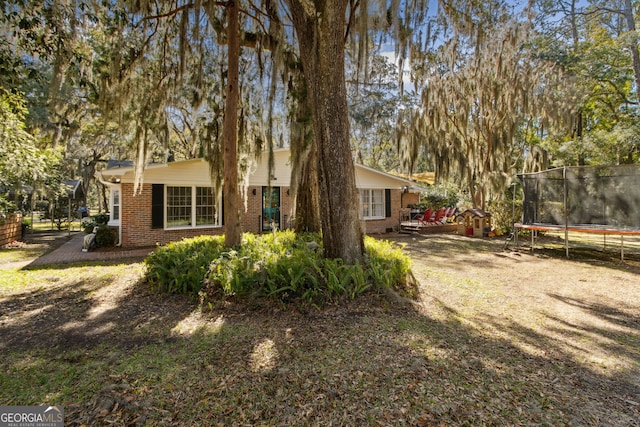 view of front of house featuring brick siding and a trampoline