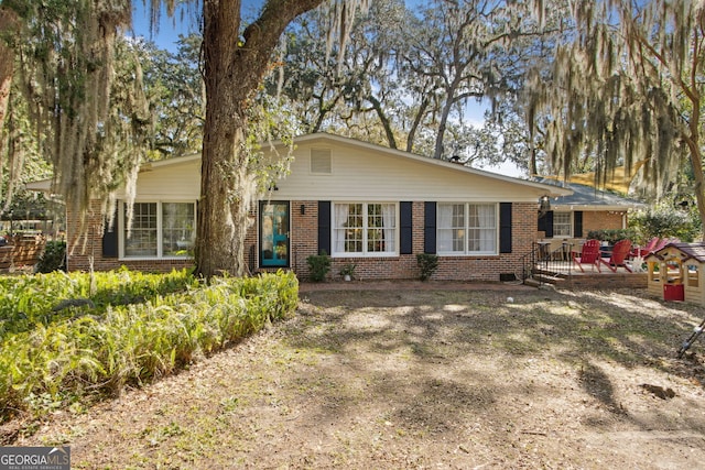 view of front of property with a deck and brick siding