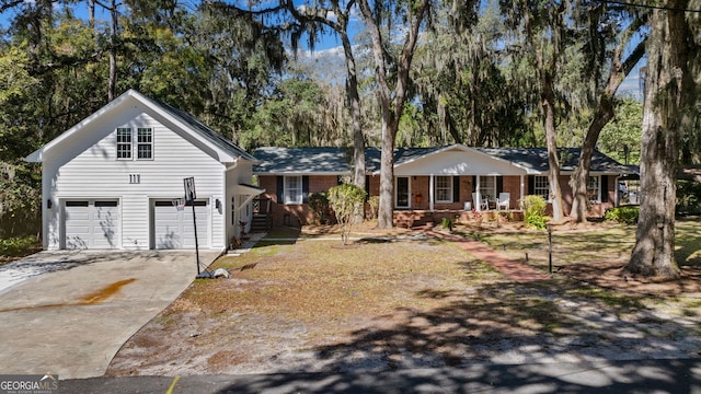 view of front facade featuring a garage, brick siding, covered porch, and concrete driveway