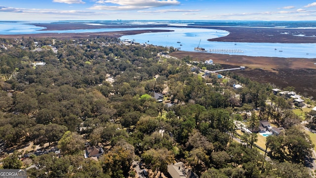 drone / aerial view featuring a wooded view and a water view