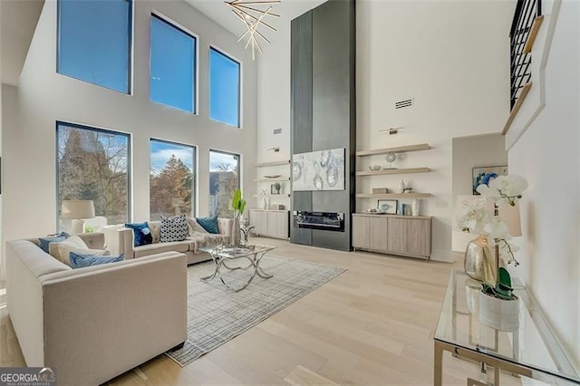 living room featuring light wood-style floors and a high ceiling