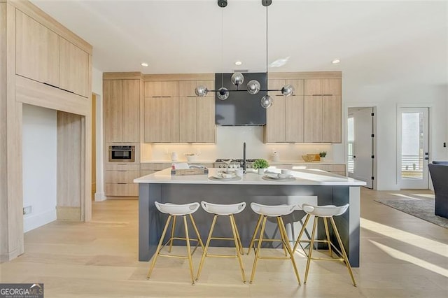 kitchen featuring light countertops, modern cabinets, appliances with stainless steel finishes, and light brown cabinetry