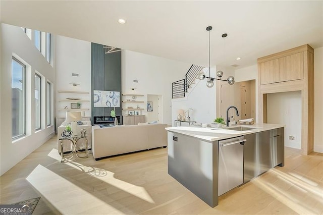 kitchen featuring dishwasher, open floor plan, a wealth of natural light, and a sink