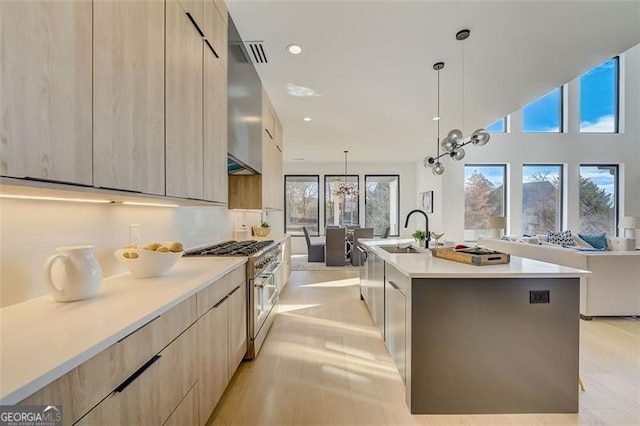 kitchen featuring high end stainless steel range oven, modern cabinets, and light brown cabinets