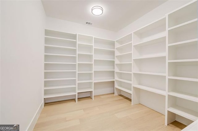 walk in closet with visible vents and wood finished floors