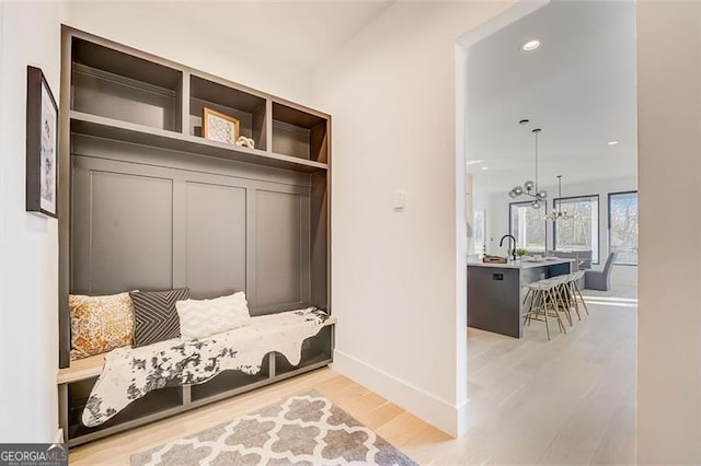 mudroom featuring baseboards, recessed lighting, a sink, light wood-type flooring, and a chandelier