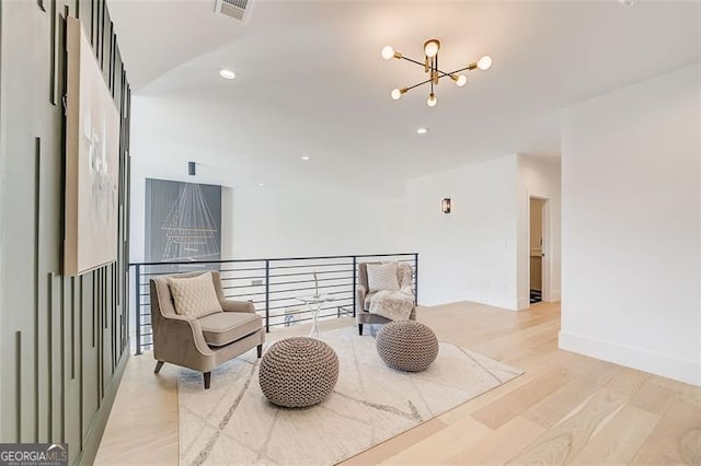 living area with visible vents, an upstairs landing, a notable chandelier, recessed lighting, and light wood-style floors