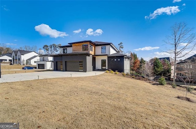 view of front facade featuring concrete driveway, stucco siding, a garage, and a front lawn