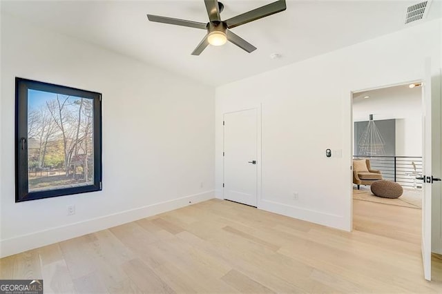 unfurnished bedroom featuring visible vents, baseboards, a ceiling fan, and light wood finished floors