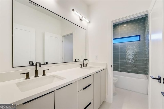 bathroom with a sink, visible vents, toilet, and double vanity