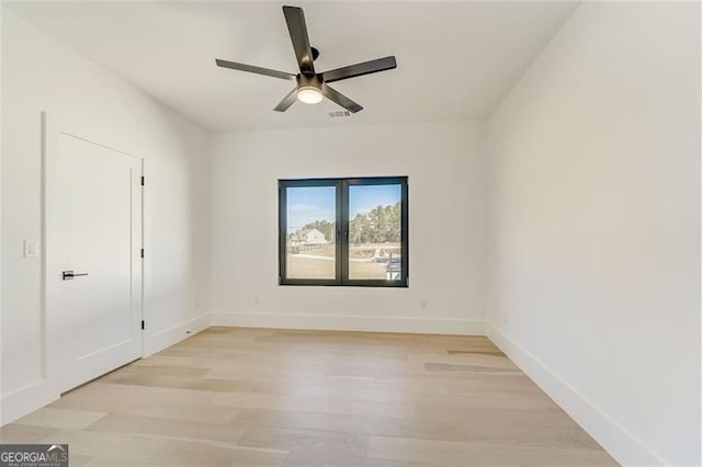 empty room featuring visible vents, light wood-style flooring, a ceiling fan, and baseboards