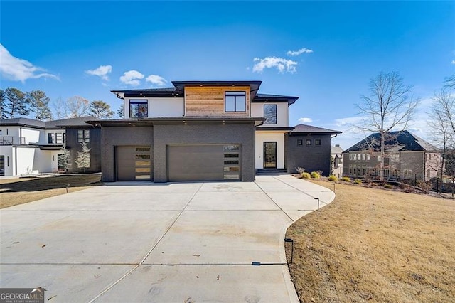 prairie-style home with a front yard, a garage, and driveway