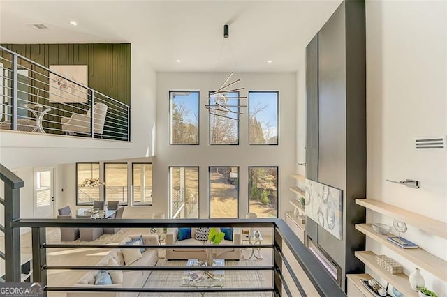 stairs featuring recessed lighting, visible vents, and a towering ceiling