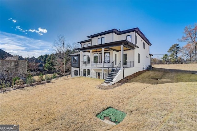 view of front facade with fence, stairway, a front yard, central AC, and stucco siding