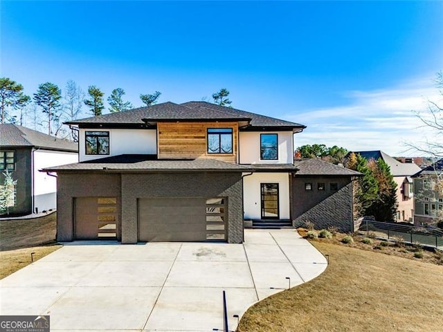 prairie-style home featuring a front lawn, fence, stucco siding, driveway, and an attached garage