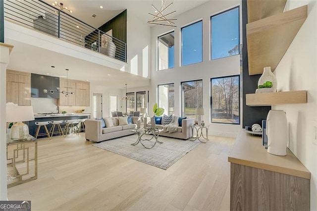 living room with light wood-style floors and a chandelier