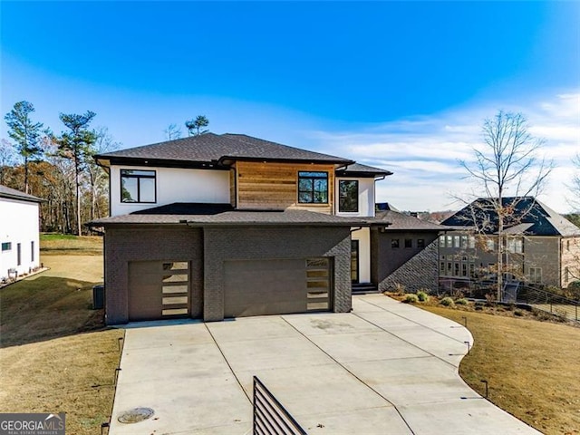 view of front of home with a front yard, driveway, roof with shingles, stucco siding, and a garage