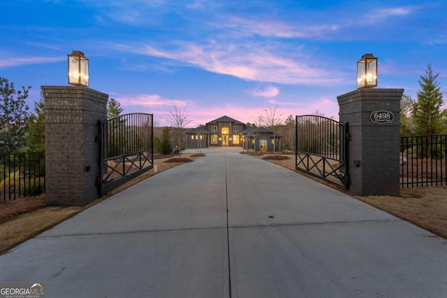 gate at dusk featuring fence